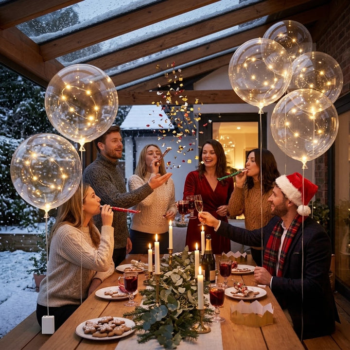 Convives trinquant autour d'une table de fête d'hiver, entourés de ballons transparents illuminés et de confettis 2