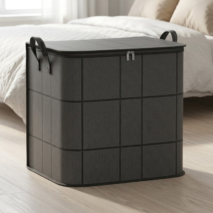 Sac de rangement gris anthracite à carreaux, fermé, posé sur un parquet clair au pied d'un lit. 1