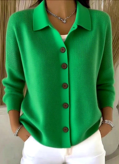 Même cardigan en vert vif, porté mains dans les poches avec un pantalon blanc, boutons marron et col décontracté visibles. 5