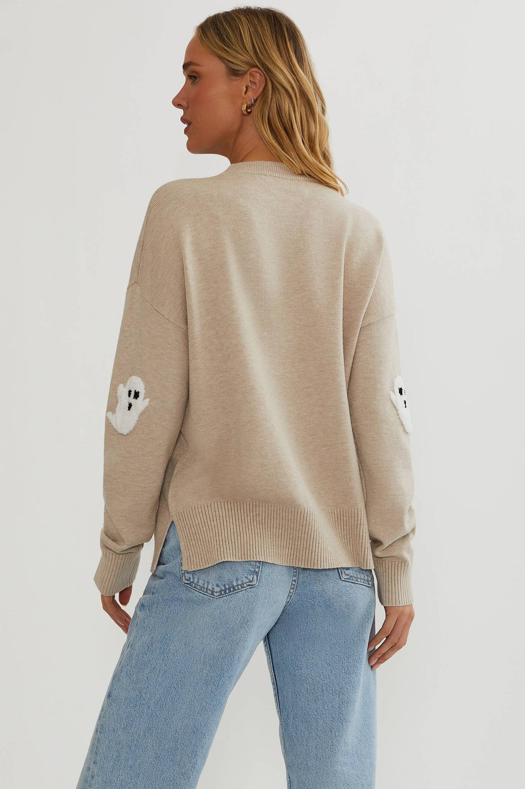 Pull beige vu de dos sur mannequin, dos uni, fente latérale au bas côtelé et fantômes blancs aux coudes. 5