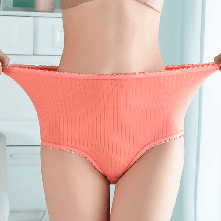 Culotte côtelée orange à taille haute portée par une femme qui étire l'élastique des deux mains pour montrer sa souplesse. 1