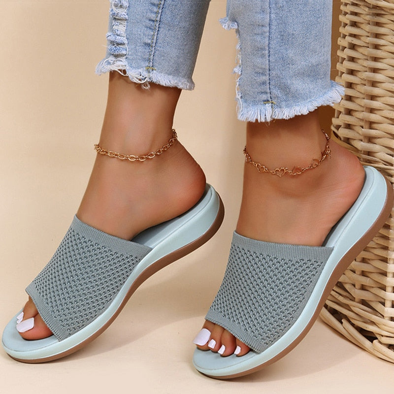 Mules grises en maille ajourée à semelle bleu clair, portées avec une chaîne de cheville 3