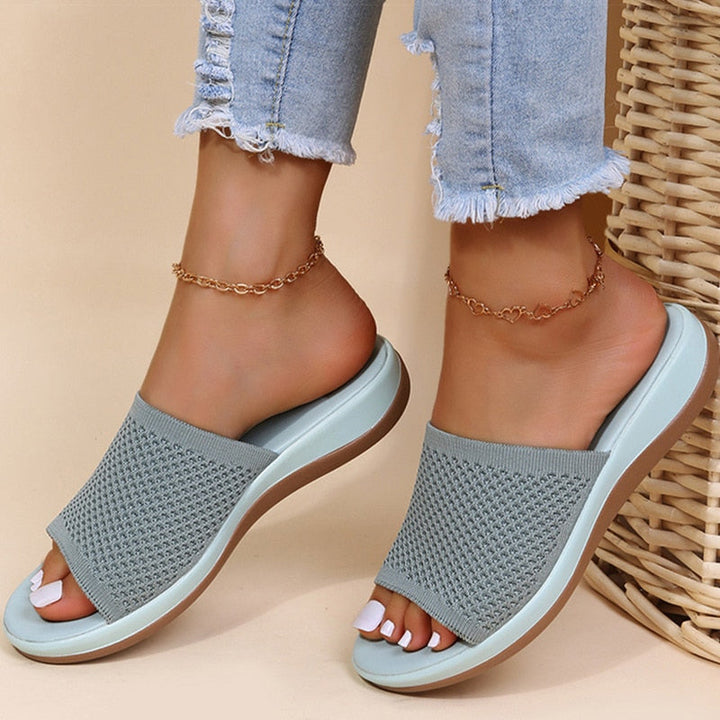 Mules grises en maille ajourée à semelle bleu clair, portées avec une chaîne de cheville 3