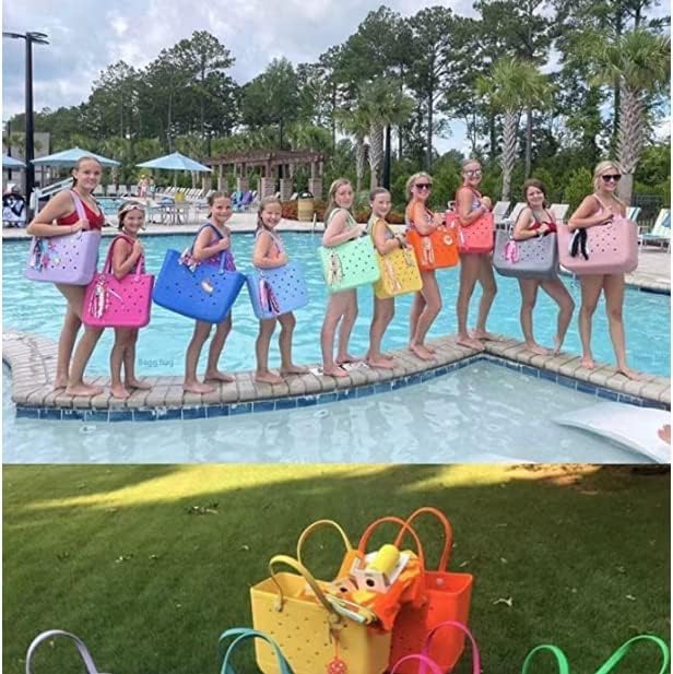 Groupe de filles en maillot de bain alignées au bord d'une piscine, chacune portant un sac cabas de couleur différente. 26