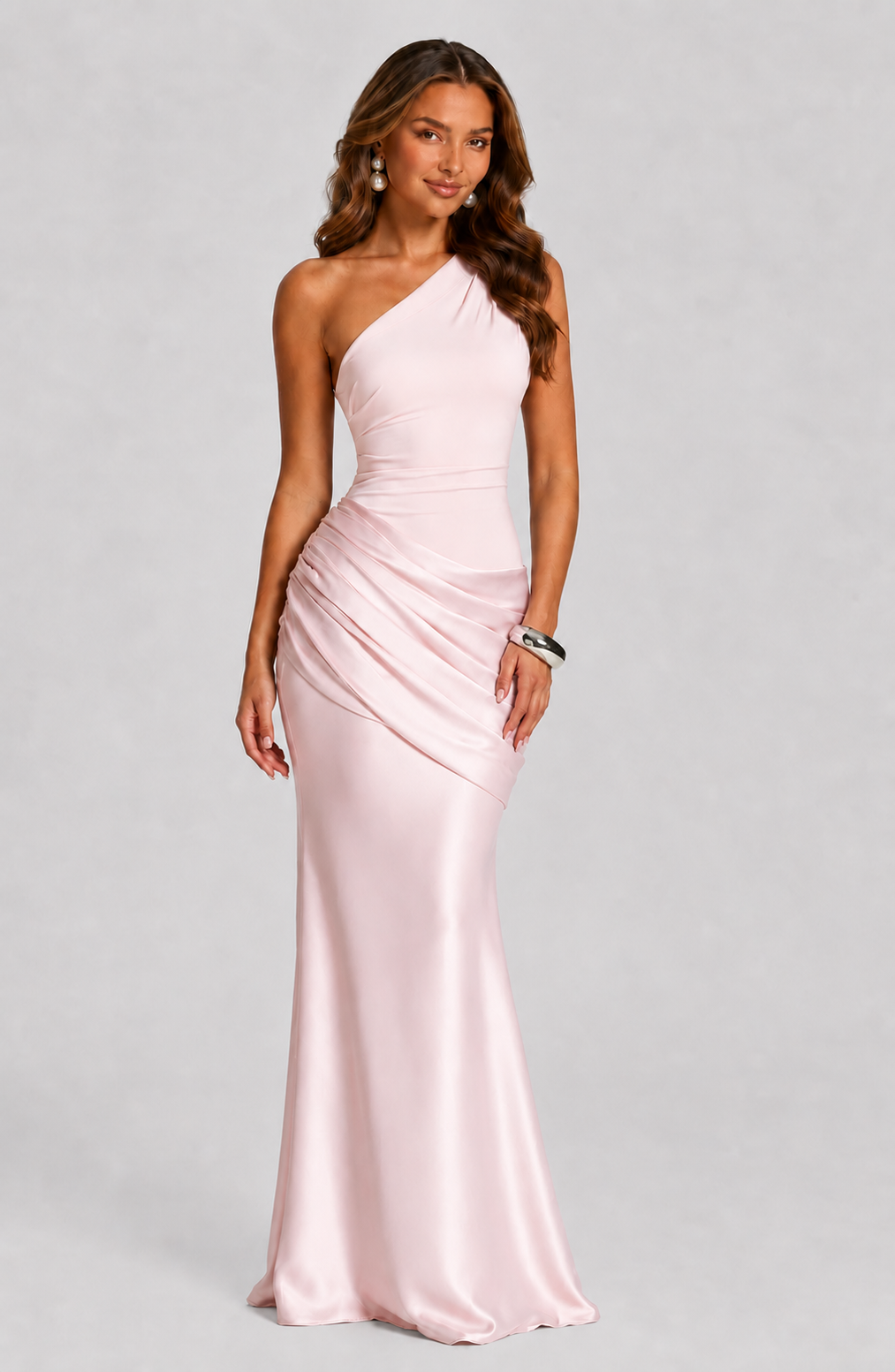 Robe rose pâle portée de face avec boucles d'oreilles perles et bracelet argenté, drapé en biais sur la hanche. 12