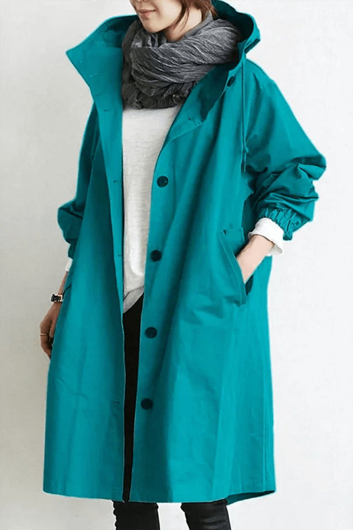 Trench bleu canard à capuche, boutonné, porté avec écharpe grise et pull blanc, vue de face 2