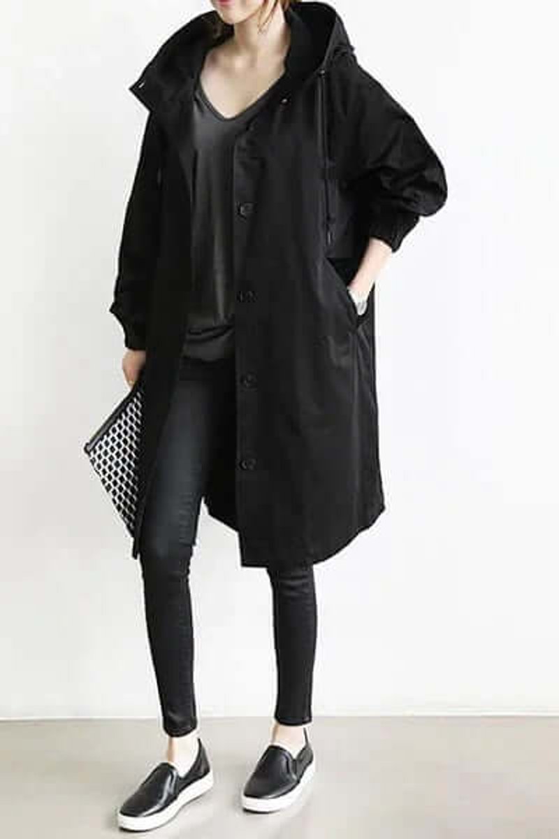 Trench noir long à capuche, porté avec jean noir, baskets et pochette à motifs, tenue complète 3