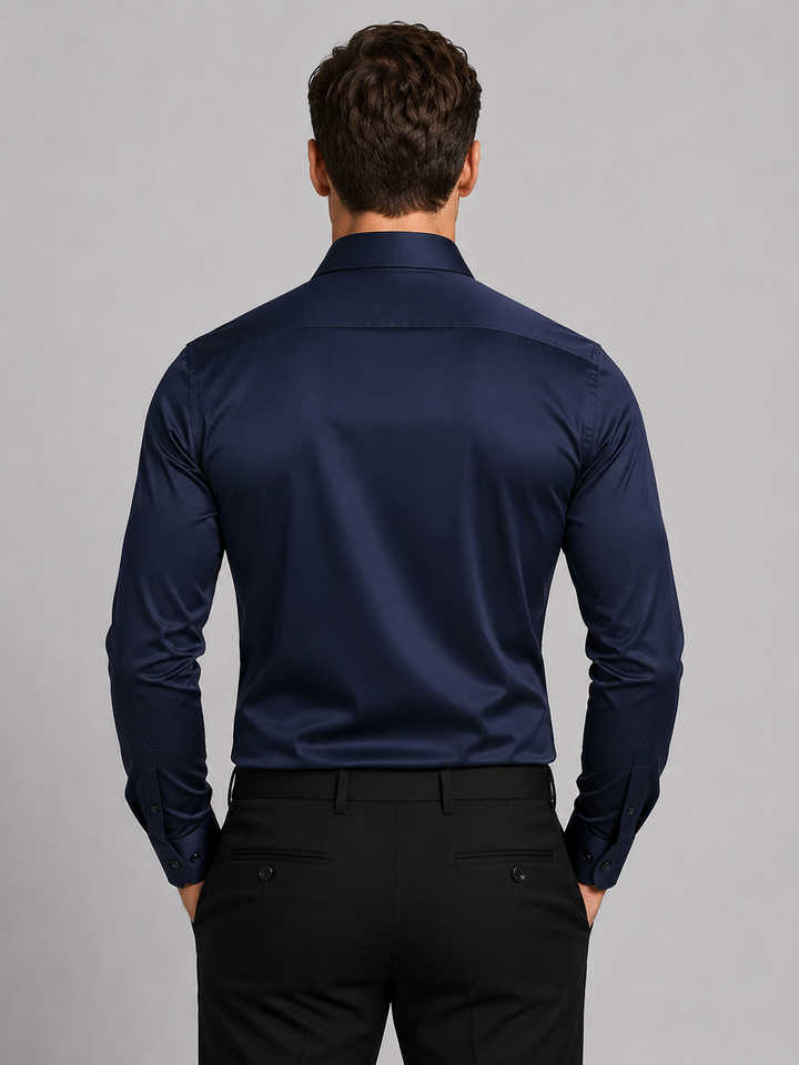 Vue de dos de la chemise bleu marine portée avec un pantalon noir, montrant l'empiècement des épaules et les poignets boutonnés. 6