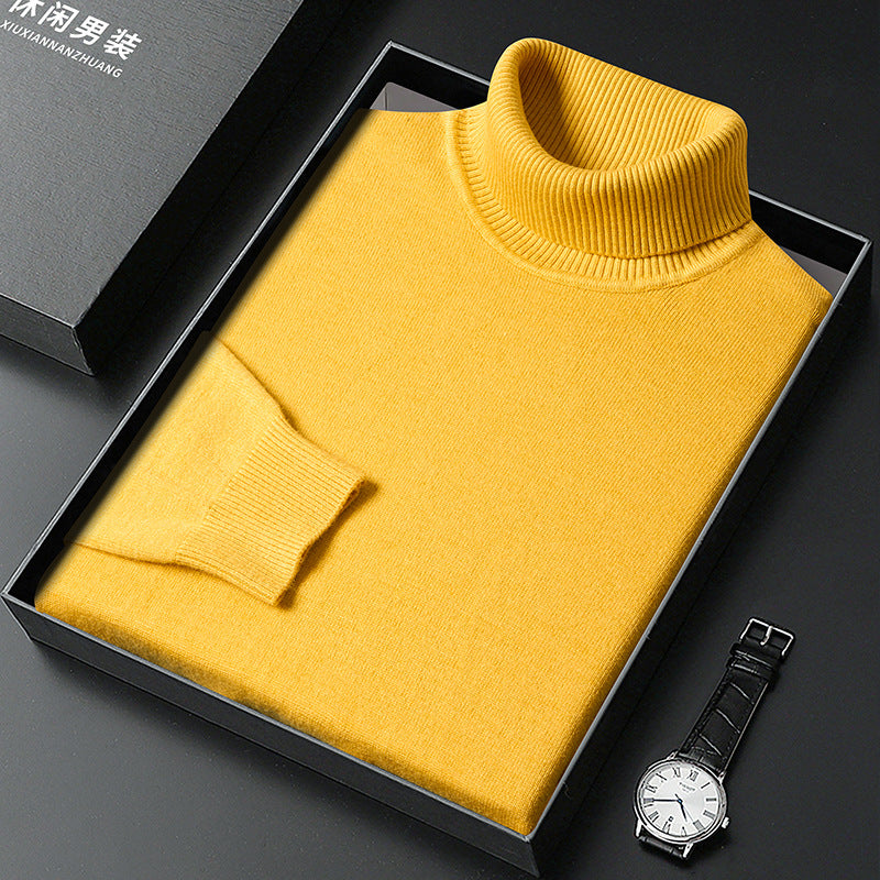 Pull à col roulé jaune plié dans une boîte noire ouverte avec son couvercle, montre à cadran blanc et bracelet cuir à côté. 9