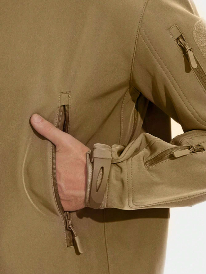 Gros plan sur une main glissée dans la poche zippée de la veste beige, avec poignet à patte de serrage et poche de manche. 13